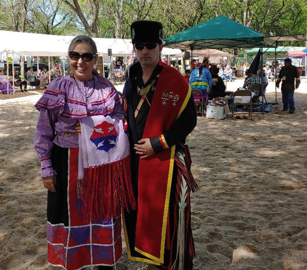 Tribal members Carl Kurtz and Laura Badonsky pose for a photo in their regalia at the Indigenous Instetute of America powwow.