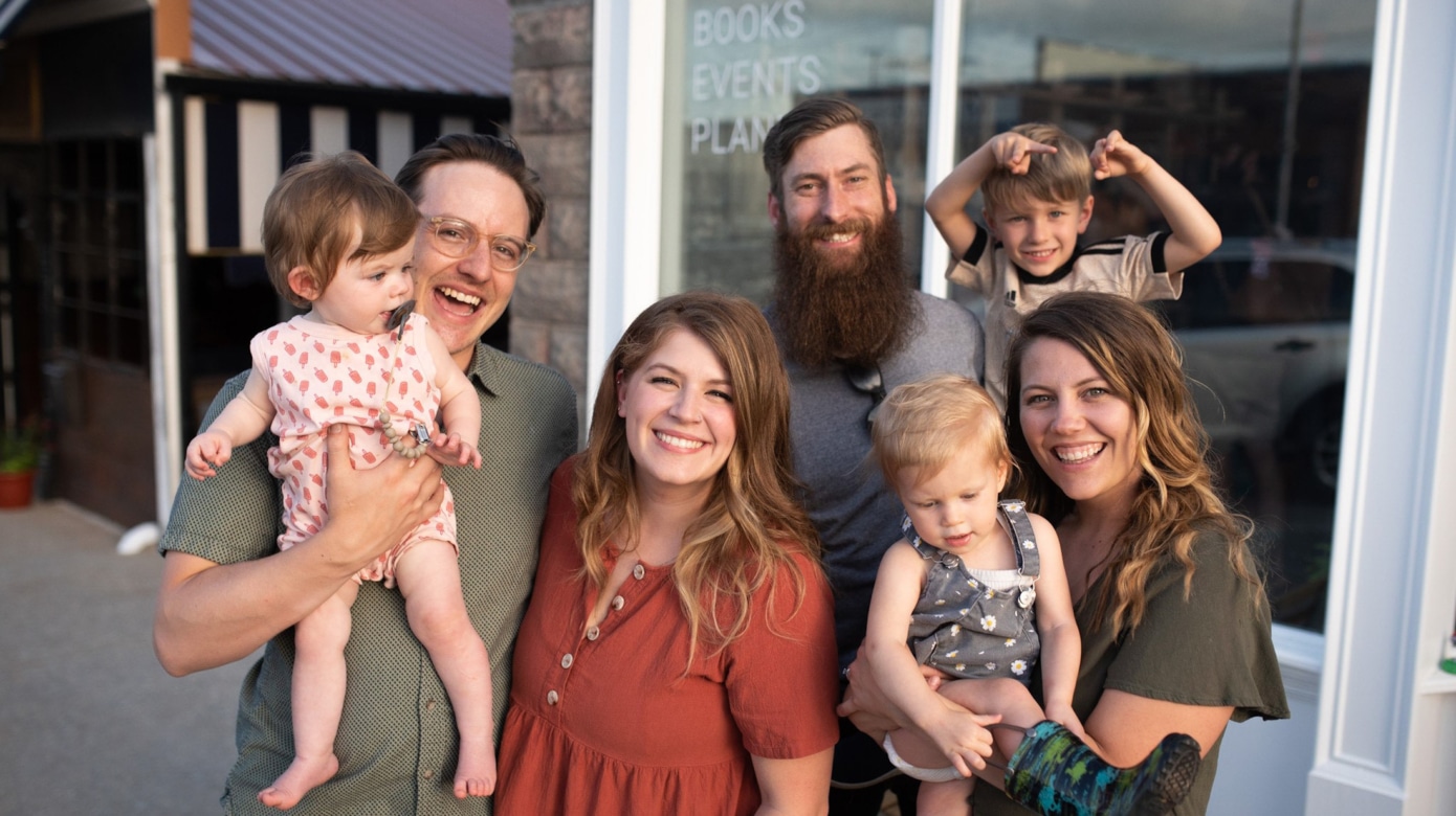 A pair of couples pose for a photo with their kids outside their jointly-owned business, Comma Cafe in Shawnee, Oklahoma. Caught mid-laugh, the photo displays a comfortable and warm friendship - the basis for their business as well.