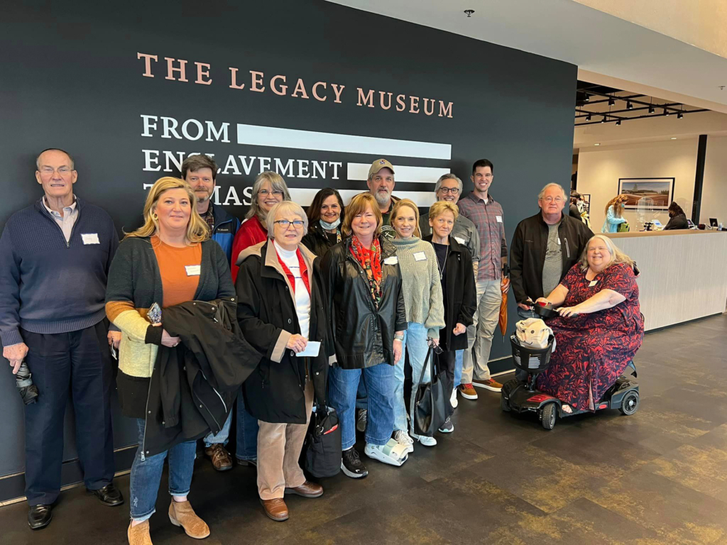 Members of CPN District 2 stand in front of a mural on the wall of The Legacy Museum in Montgomery, AL.