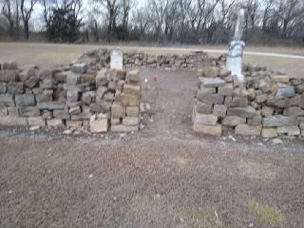 Photo of a crumbling stone wall around a cemetery.
