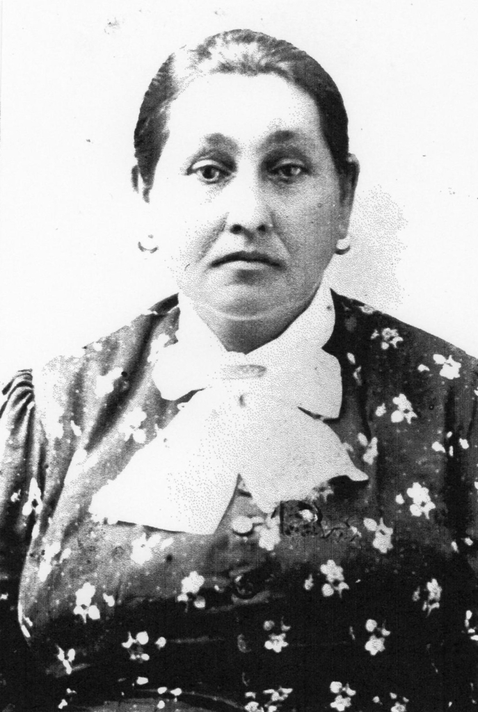 Black and white portrait of Madeline LaFromboise Denton in a floral blouse with a bow at the neck.