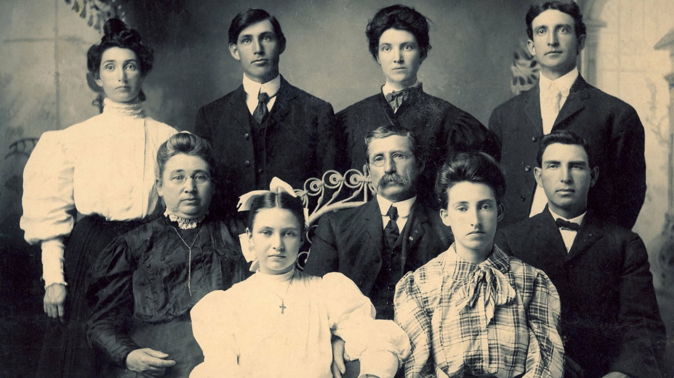 Archival photo of Francis LaReau with his two parents and six siblings. Each looks straight ahead toward the camera, mostly blank expressions on their faces. The two youngest in the front row have more direction in their eyes and border on expression.
