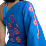 An example of Mound Builder motifs that Deer works to preserve in her work. Pink and orange patterns of circles divided into four quadrants and circles with triangles lining the outside appear against a bright blue sleeve and back.