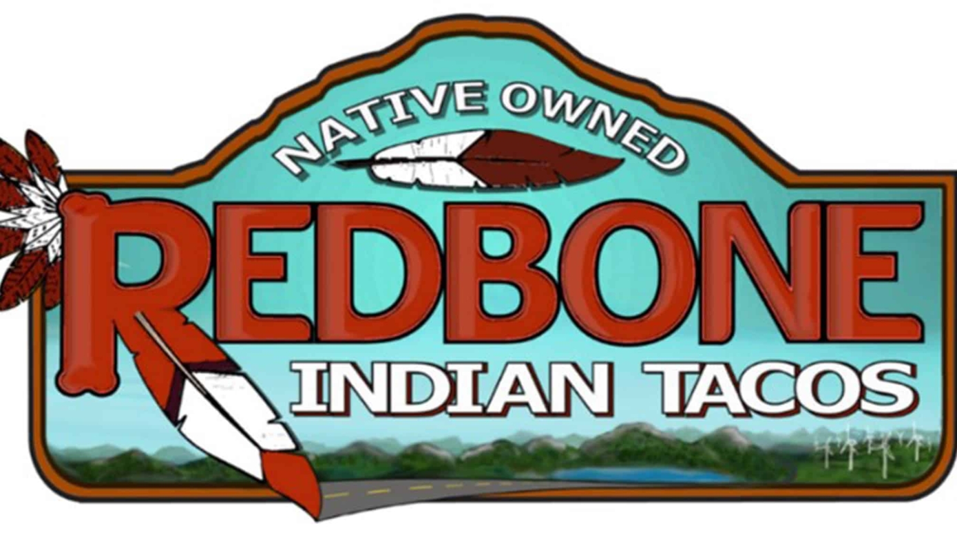 The Redbone Indian Tacos food truck logo features the name in red and white text over a depiction of the local landscape, with highway, wind turbines, lakes, and trees.