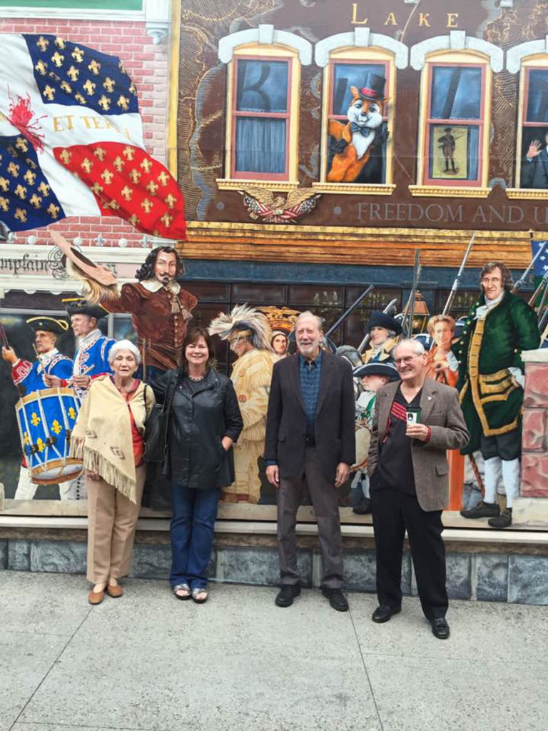 Group photo in front of a painted festive building facade.
