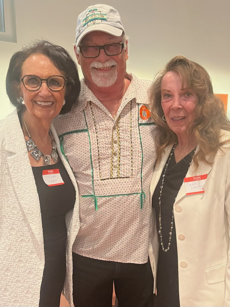 Vice-Chairman Linda Capps and Legislator Gene Lambert, both wearing black shirts and white blazers, stand next to Larry Watson, wearing a light colored ribbon shirt and a ball cap.