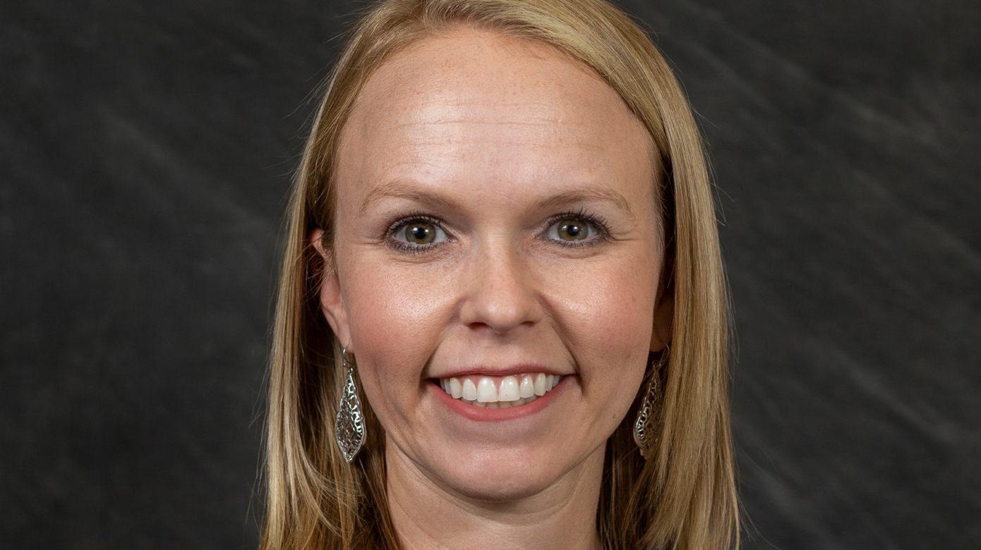 Headshot of Lauren Bristow, who wears a black blazer. Her blonde hair falls just below her shoulder.