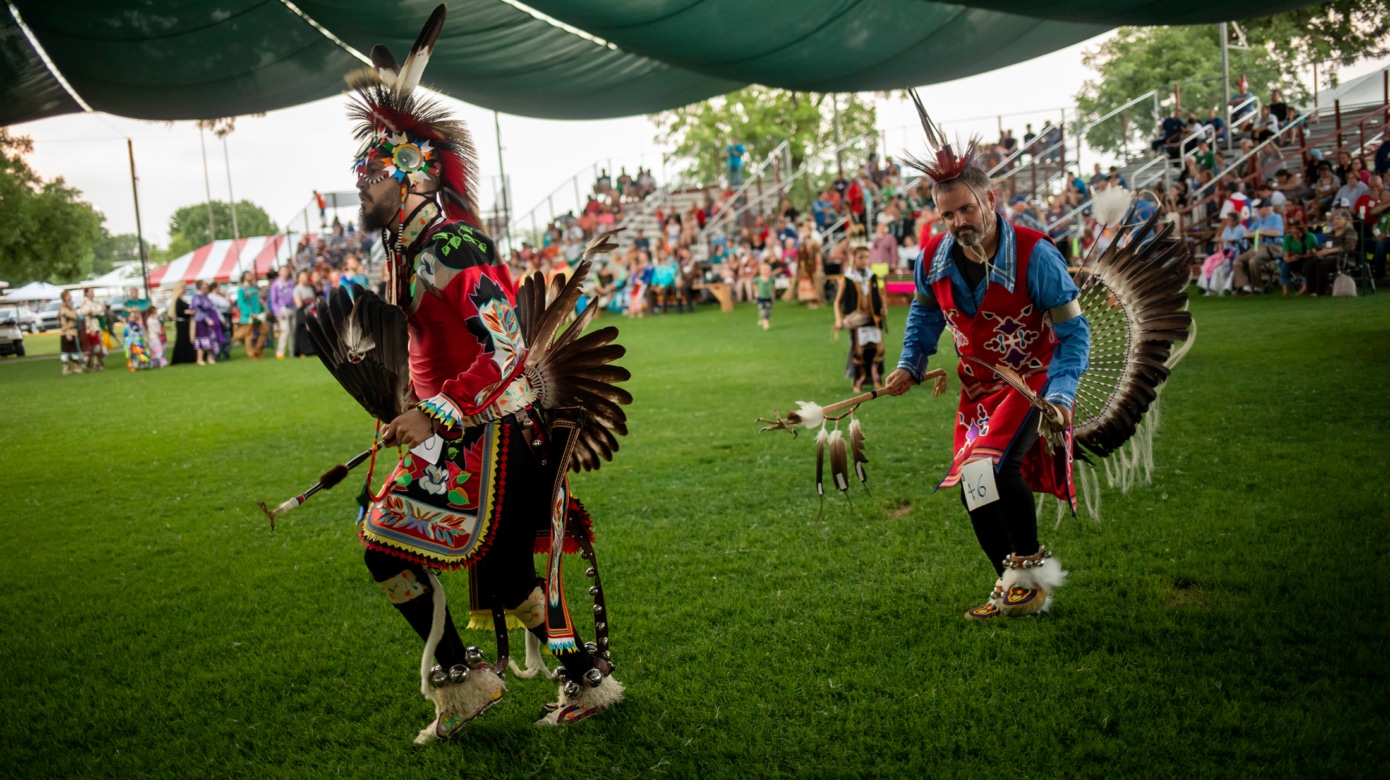Two dancers in full regalia at Grand Entry at the 2019 CPN Family Reunion Festival.