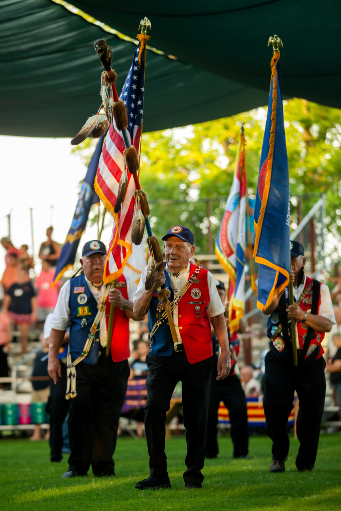 Members of the CPN Veterans Organization carry the Eagle staff and flags in the CPN Dance Arena during Grand Entry. Lyman Boursaw walks front and center, carrying the Eagle staff.