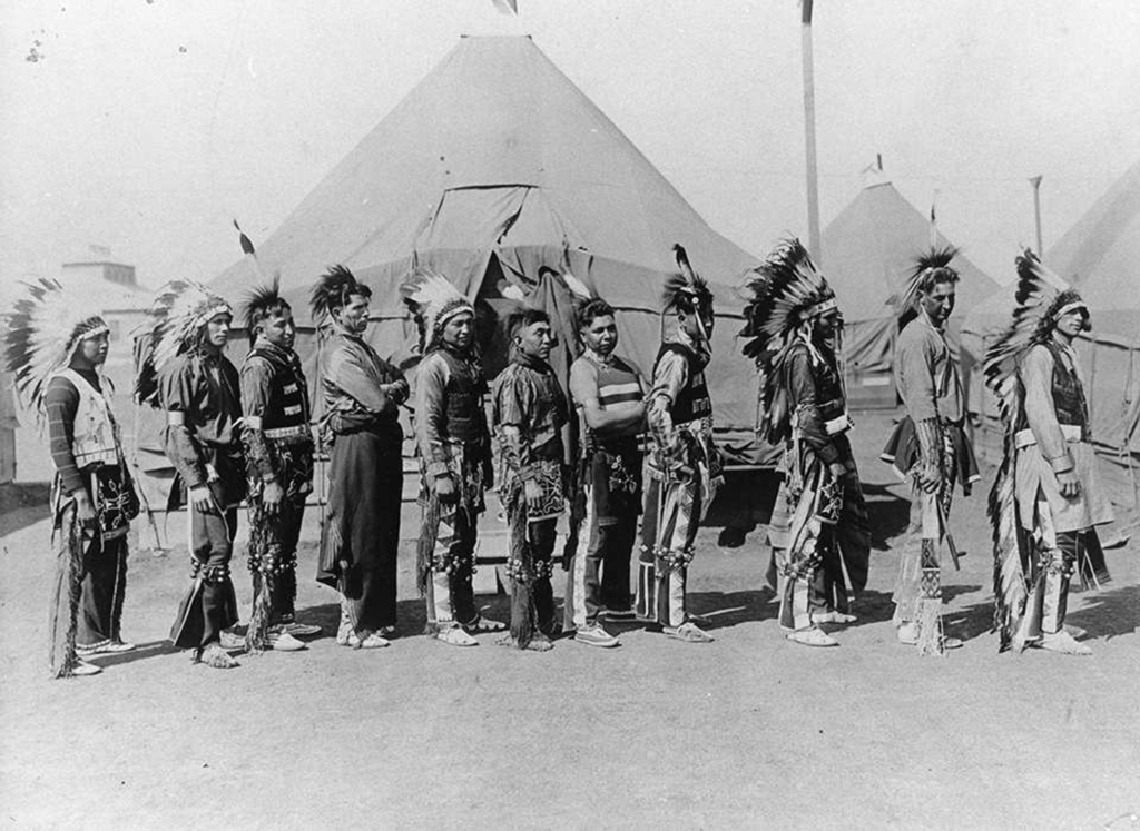 Row of 11 Native American U.S. service members wearing regalia.