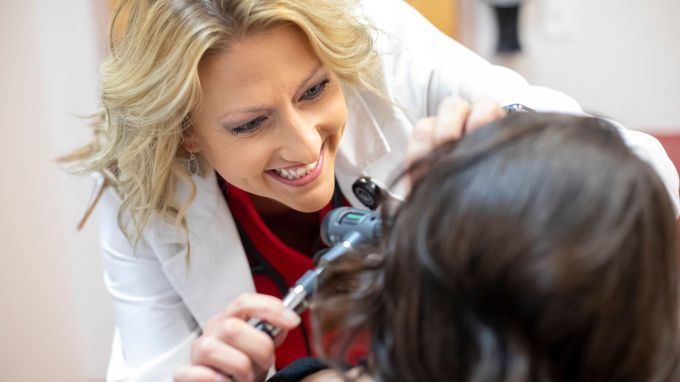 photo of a doctor examining a patient's ear.