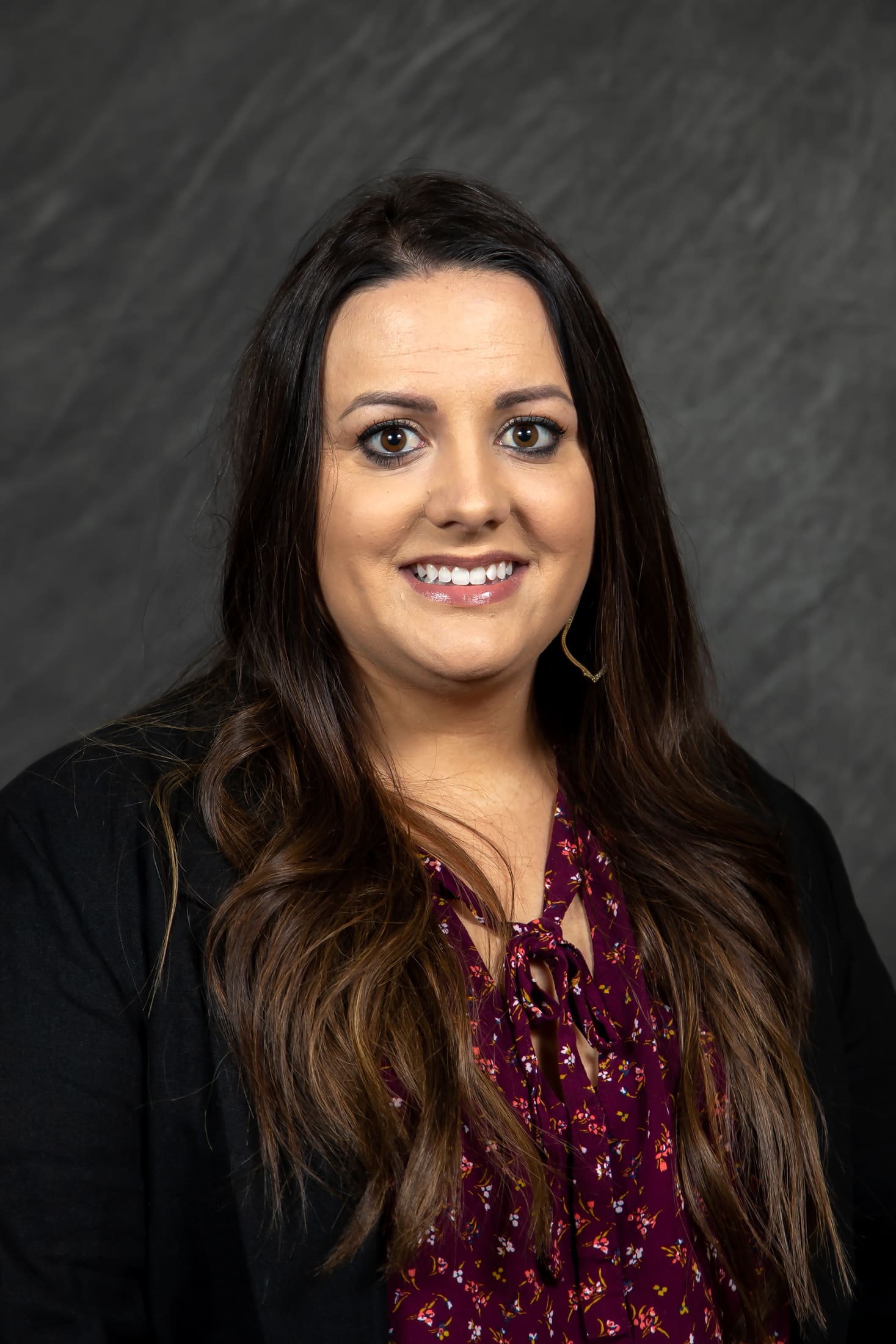 Headshot of CPN Health Services' Dr. Megan Wilson. She has long brown hair and brown eyes, and wears a purple floral blouse. 